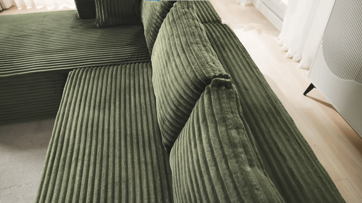 A green sectional sofa sold by WorkZen Interiors