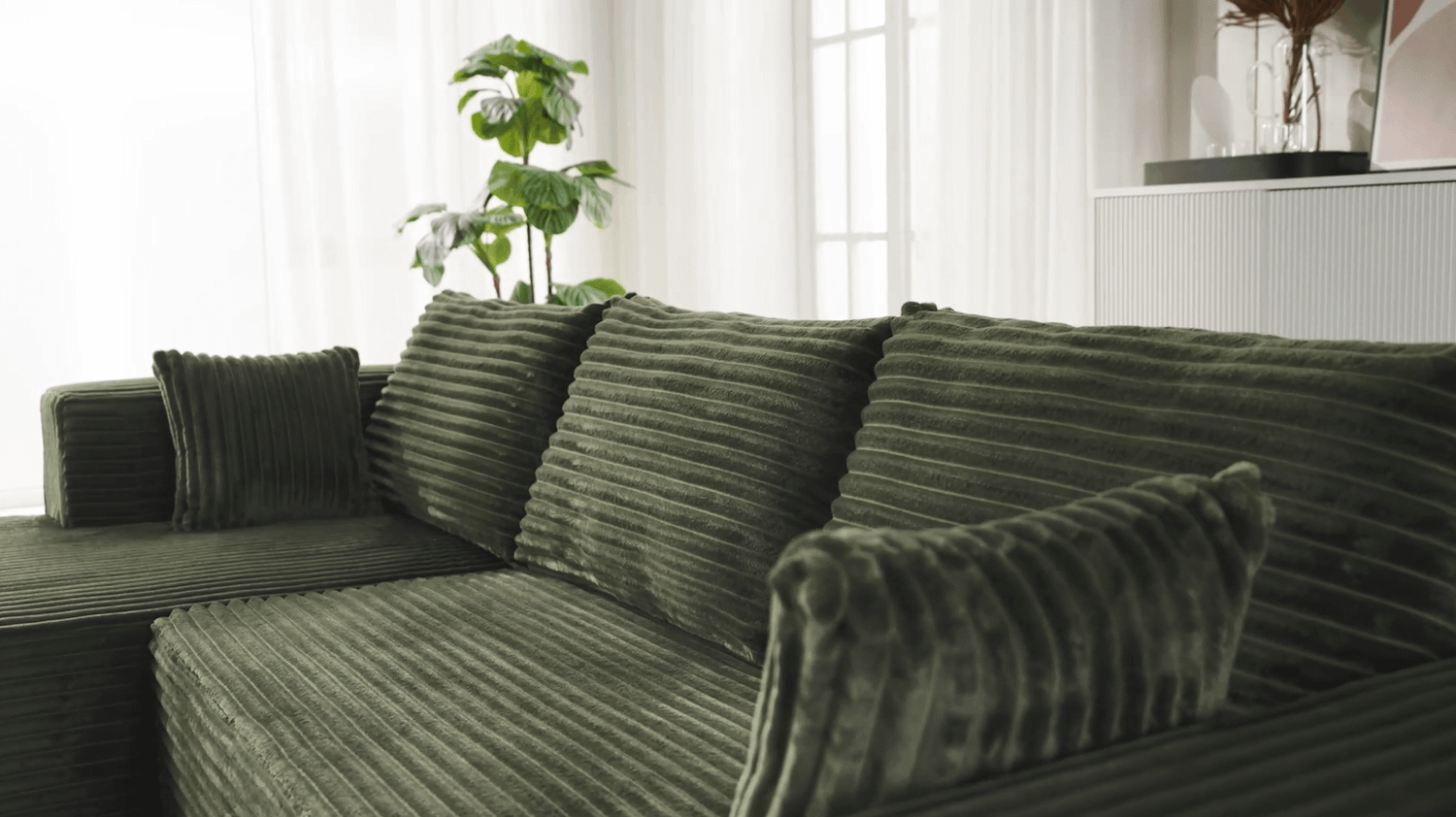 A green sectional sofa sold by WorkZen Interiors