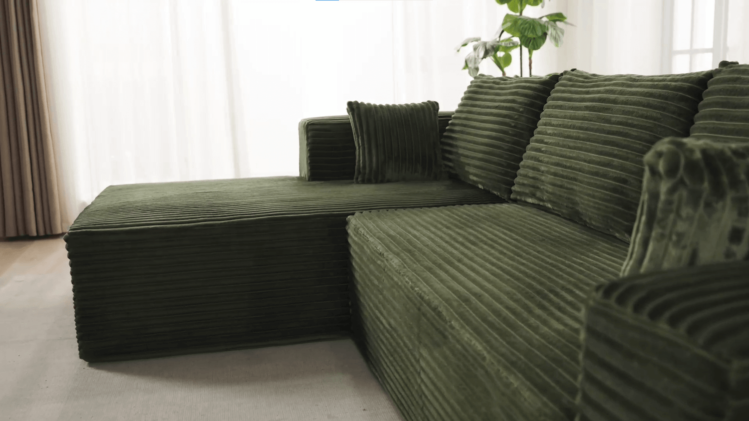 A green sectional sofa sold by WorkZen Interiors