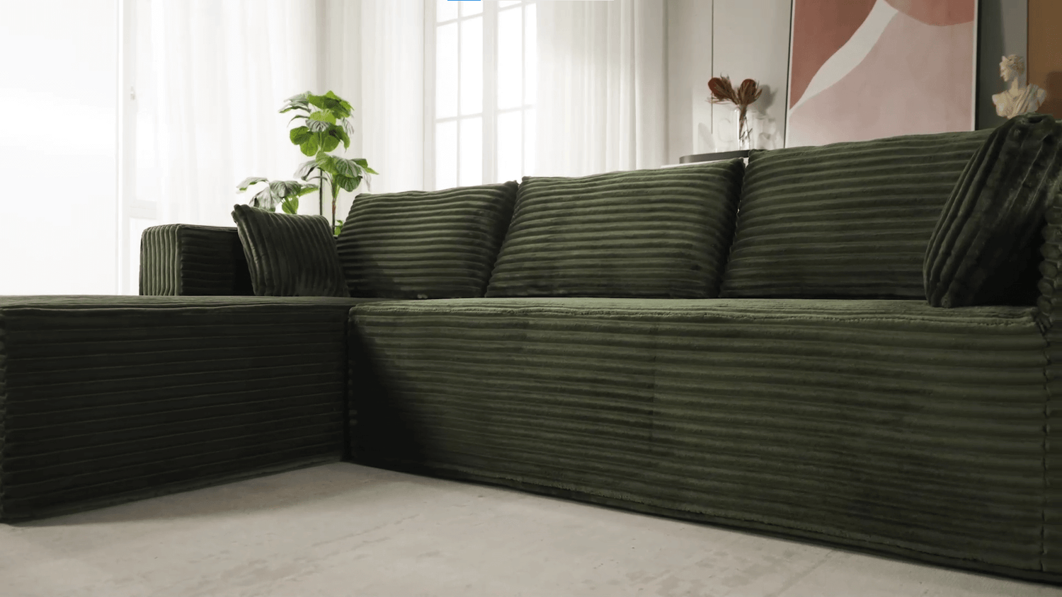 A green sectional sofa sold by WorkZen Interiors