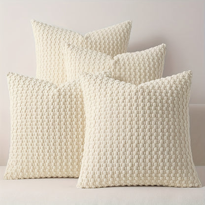 Four textured cream pillows on a light gray background