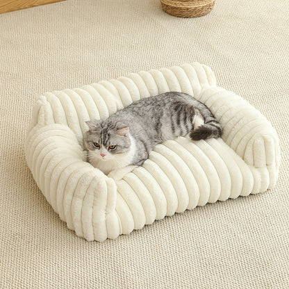 Cat lying on a plush, white cat sofa on a beige carpet