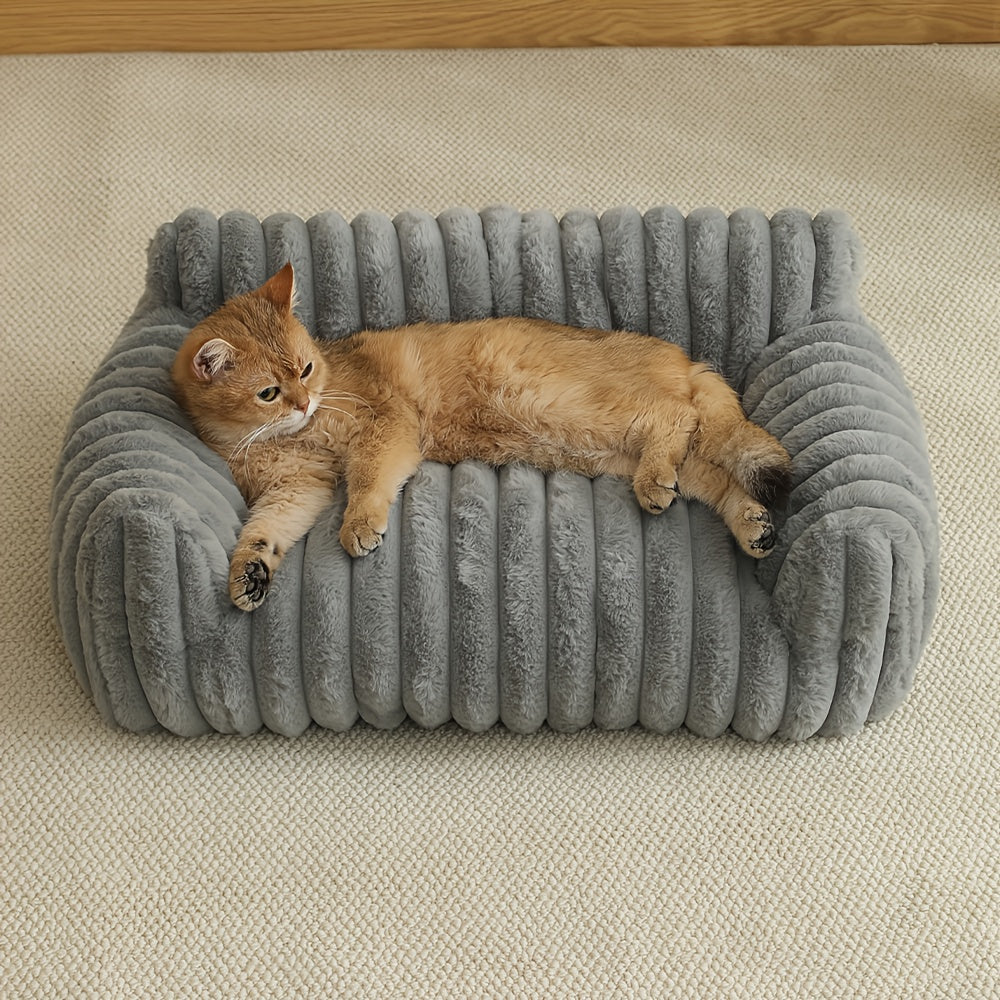 Cat lying on a gray cushioned cat sofa on a beige surface