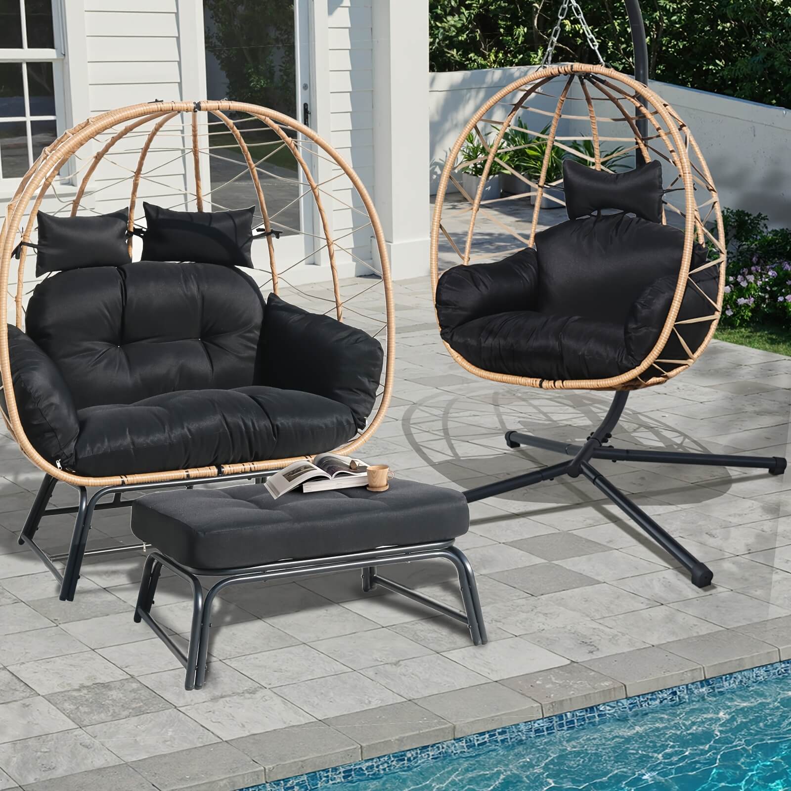Two black cushioned egg-shaped chairs on a patio by a pool