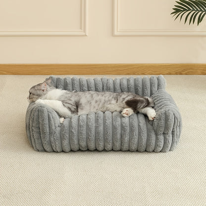 Cat sleeping on a plush gray cat sofa in a room with beige walls and a wooden floor.