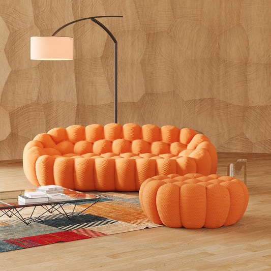Orange textured sofa and ottoman in a living room with wooden floor and wall.