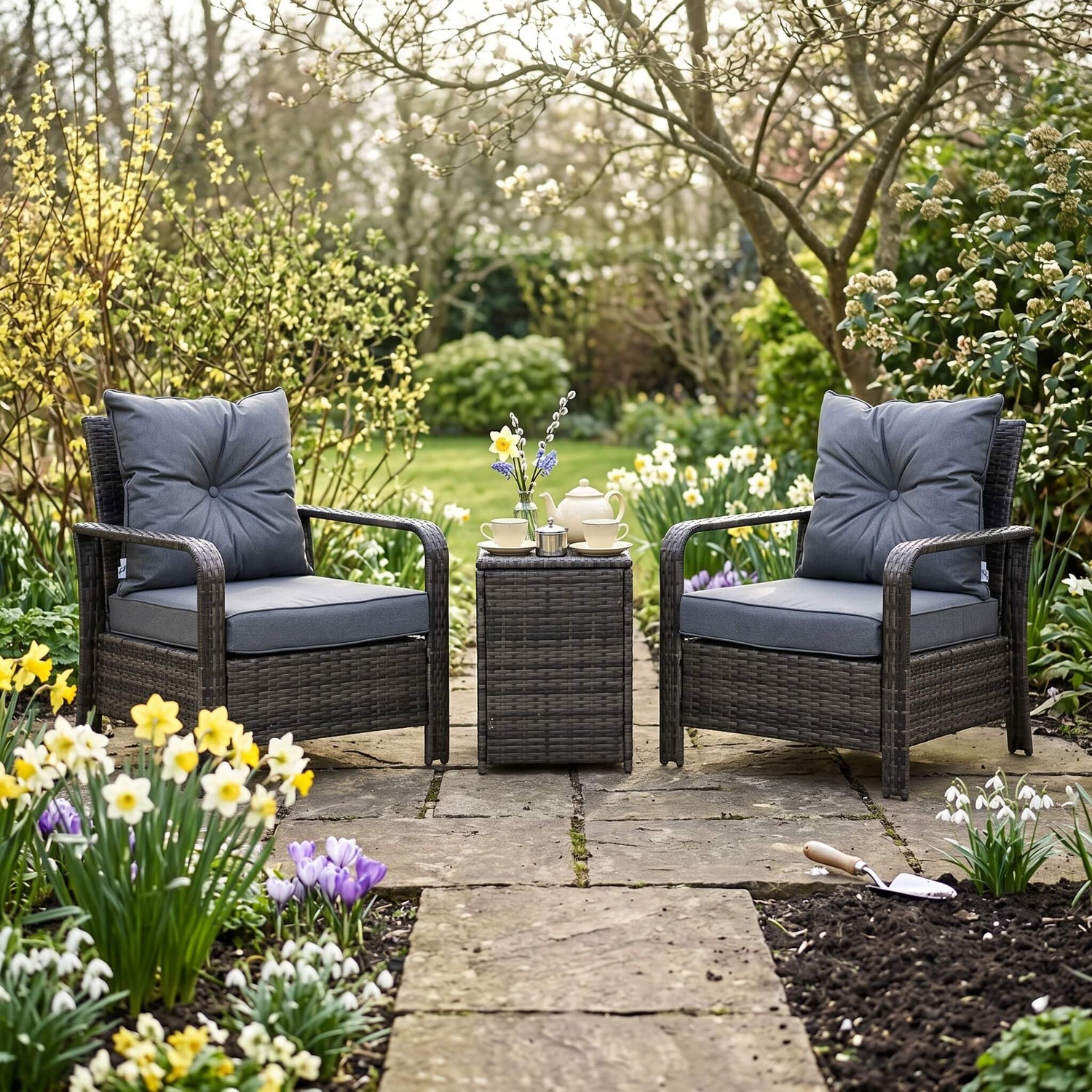 Two wicker chairs with gray cushions and a small table on a wooden deck.