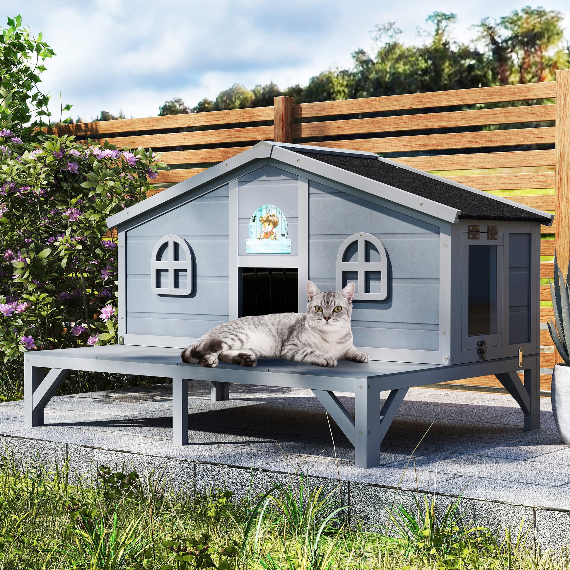 Cat lying on a gray wooden pet house in a garden setting