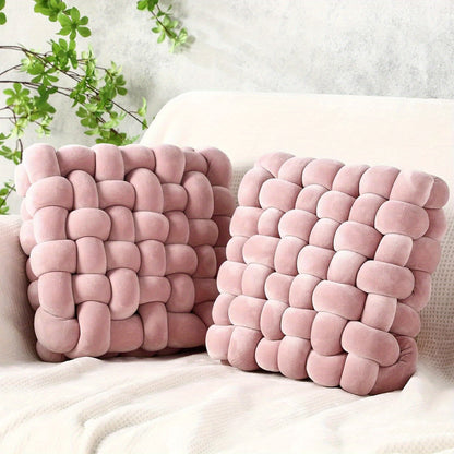 Two pink textured pillows on a white surface with a light gray background.