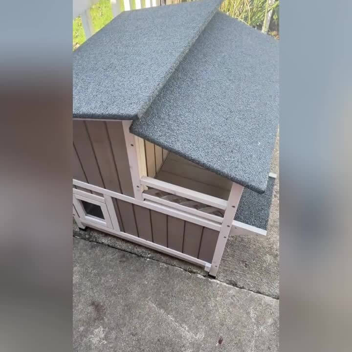 Wooden pet house with a gray roof on a concrete surface