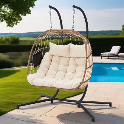 Hanging chair with white cushions on a patio by a pool