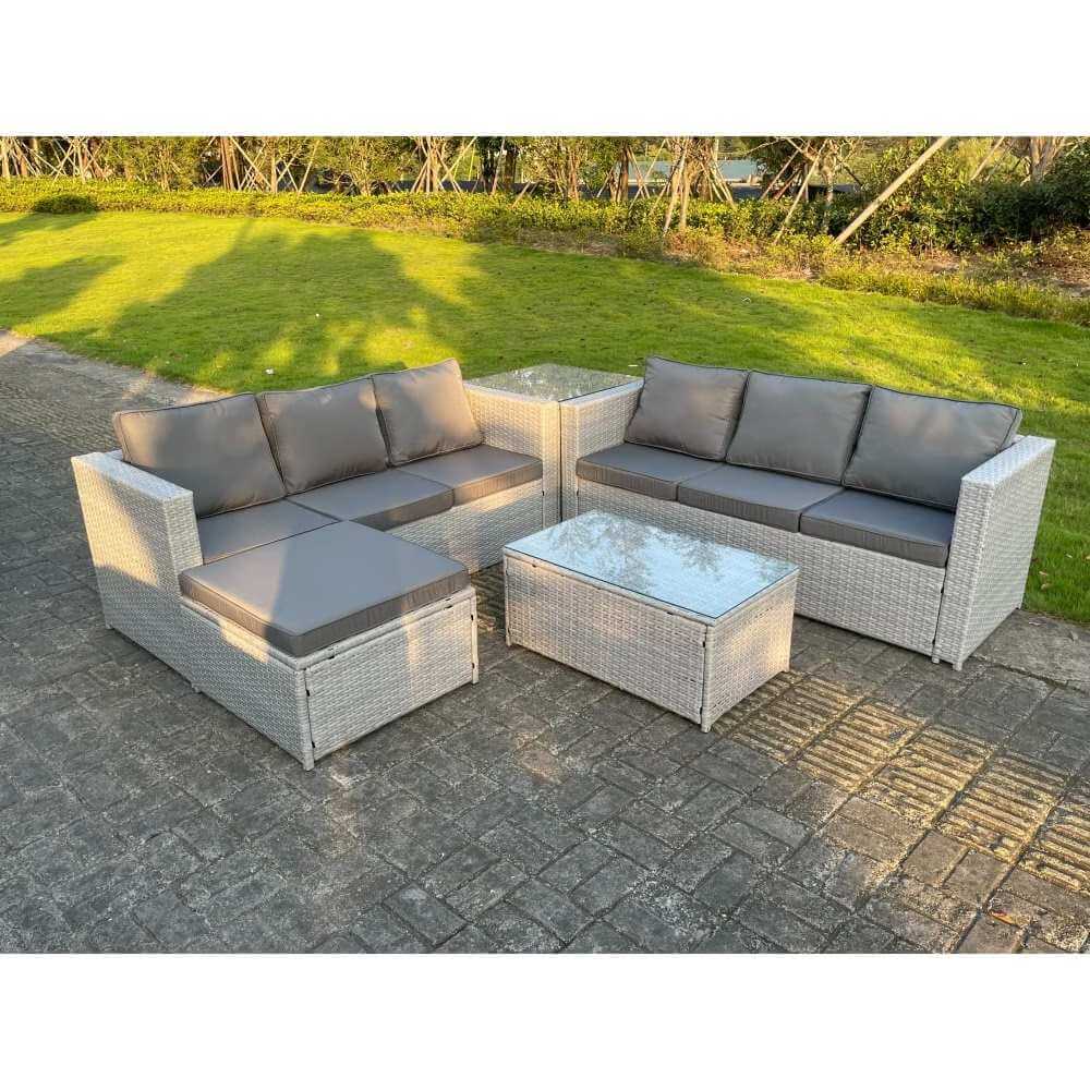 A Light Grey Outdoor Rattan Garden Furniture Set in an out garden