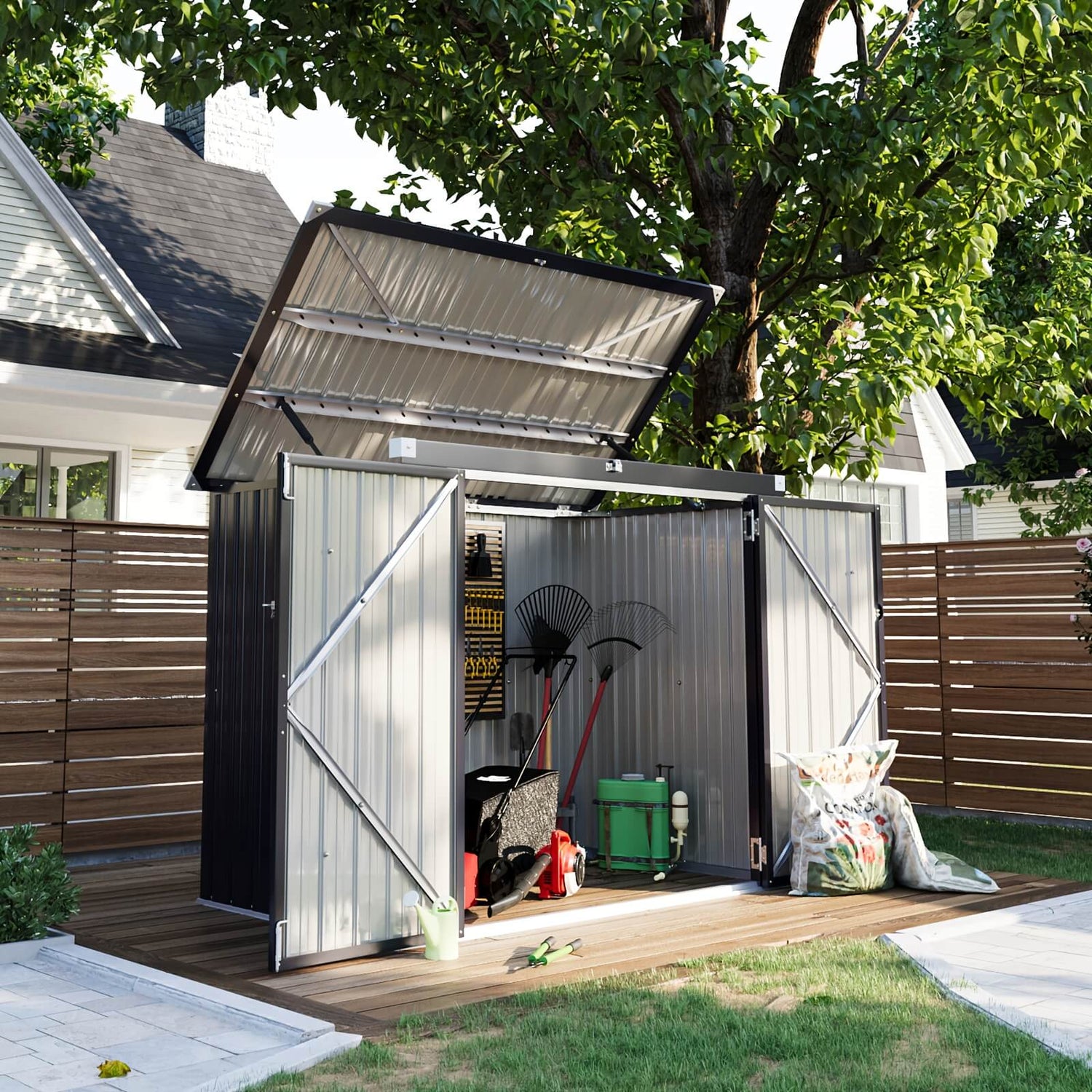 Metal garden shed with open door on a wooden deck, surrounded by greenery.