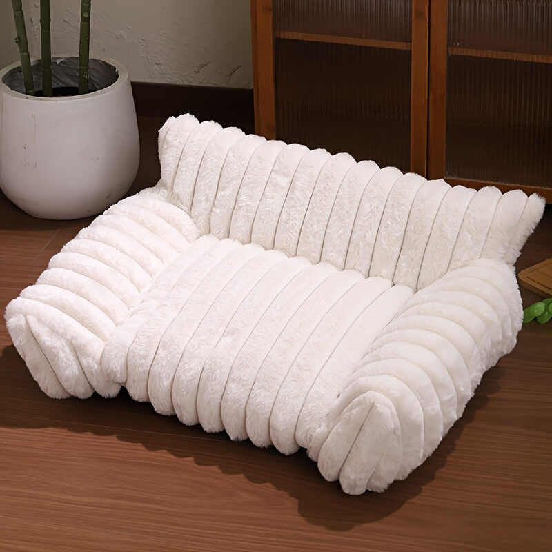 White textured cat sofa on a wooden floor with a plant in the background