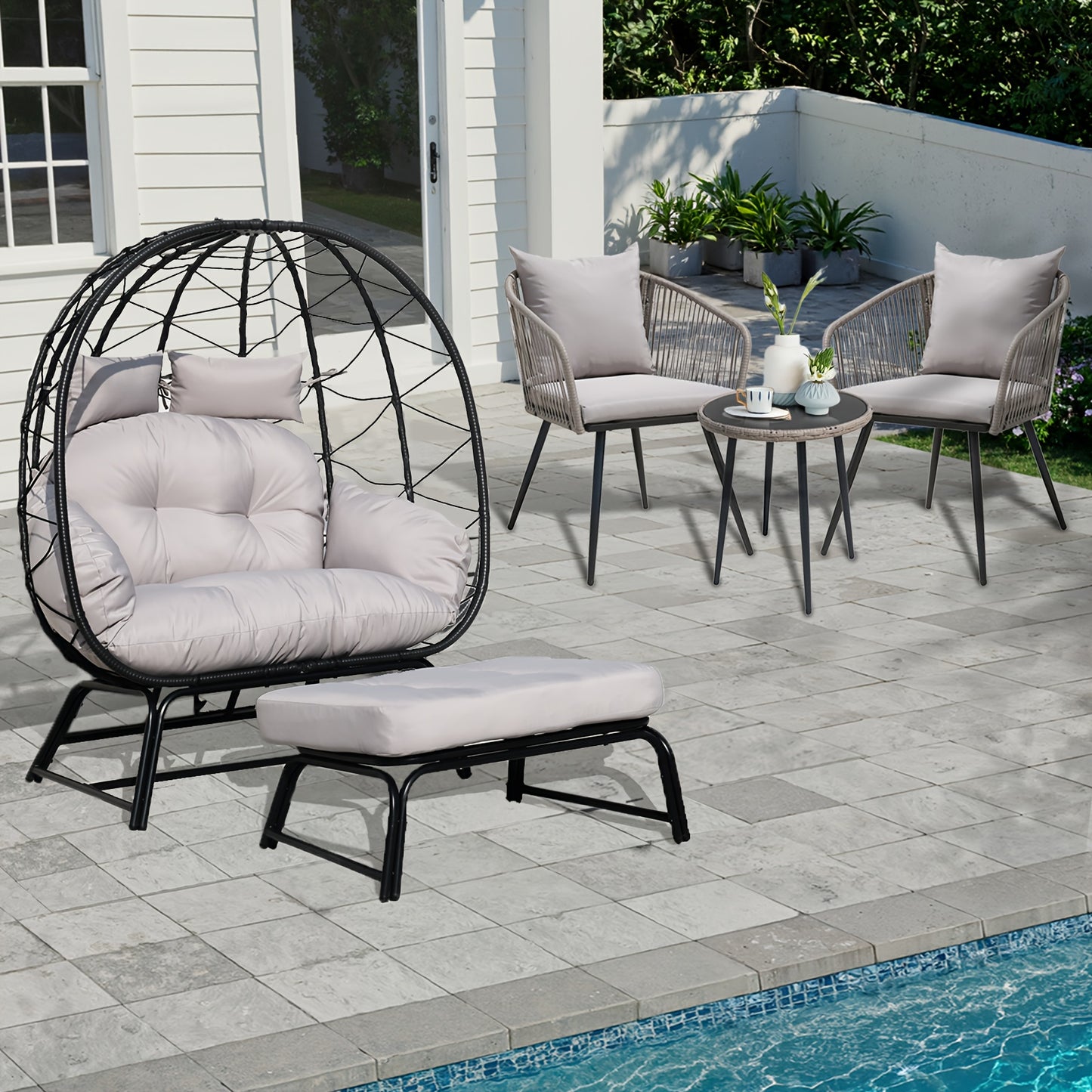 Outdoor patio furniture set with egg-shaped chair, ottoman, and two chairs with a small table by a pool.