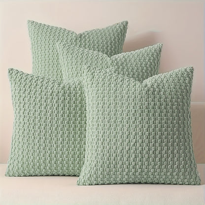 Three textured green pillows on a light pink background