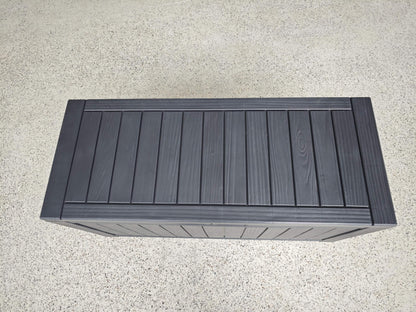 Dark gray wooden bench on a light gray surface