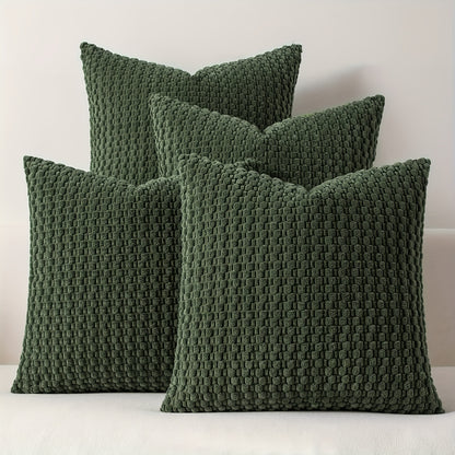 Four green textured pillows on a white surface with a light gray background