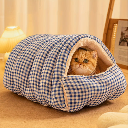 Cat peeking out from a blue and white checkered wool cat cave on a wooden floor.