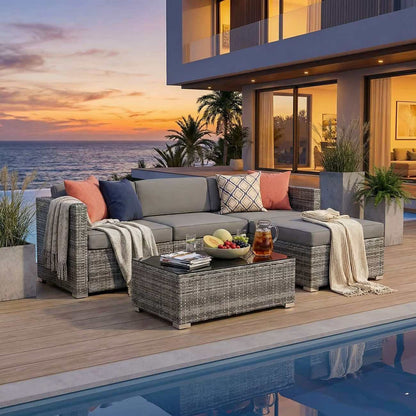 Outdoor patio with a sectional sofa, coffee table, and ocean view at sunset.