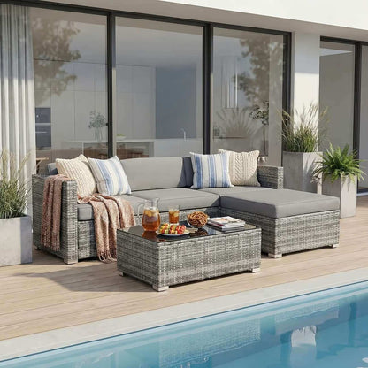Outdoor patio set with sectional sofa, coffee table, and cushions by a pool.