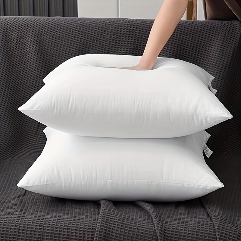 Two white pillows on a dark gray textured surface