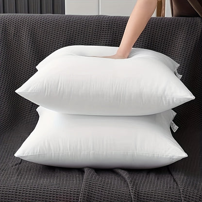 Two white pillows on a dark gray textured surface