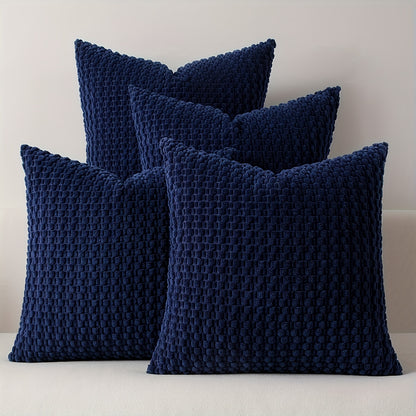 Four navy blue textured pillows on a light background