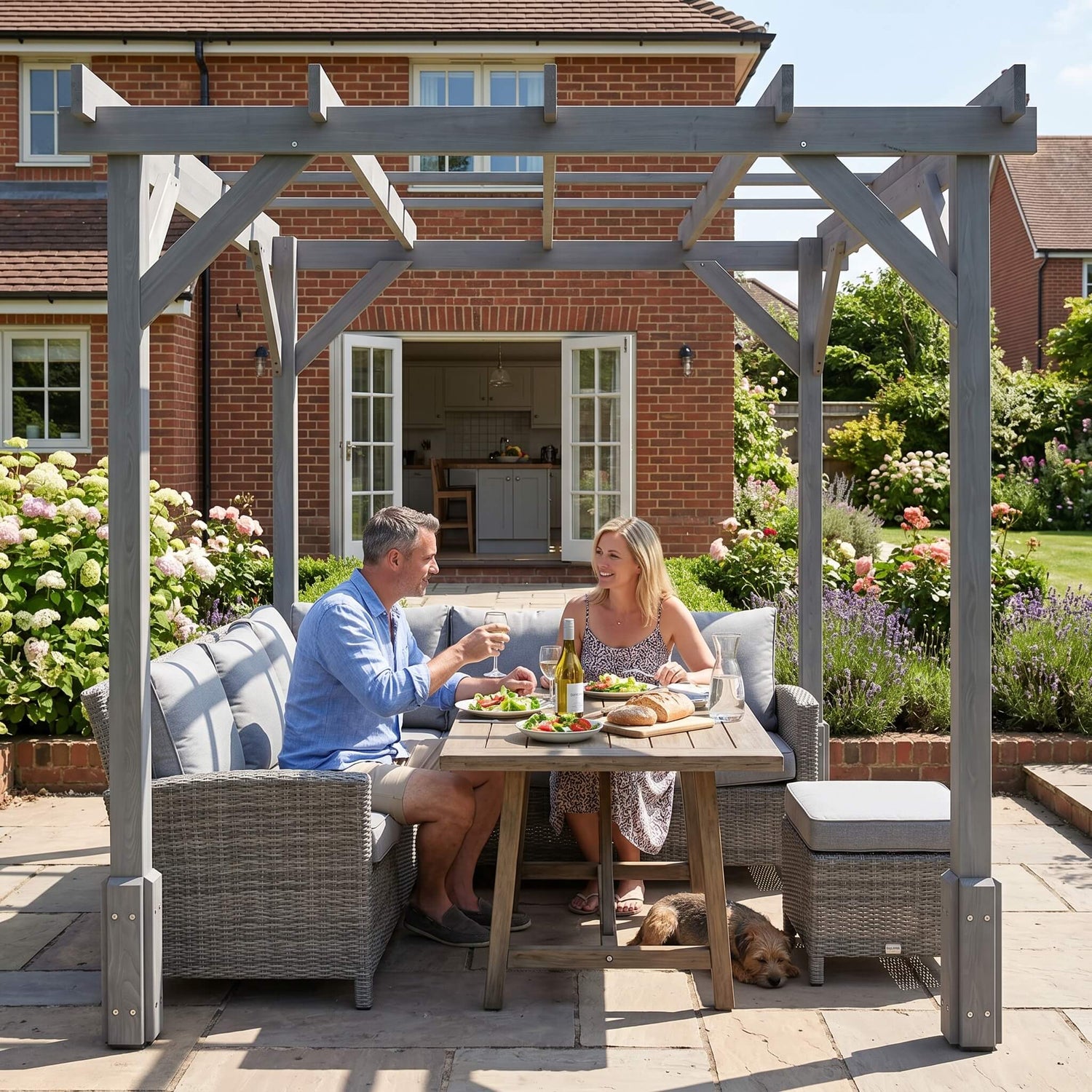 Couple enjoying a meal under a pergola in a garden setting.