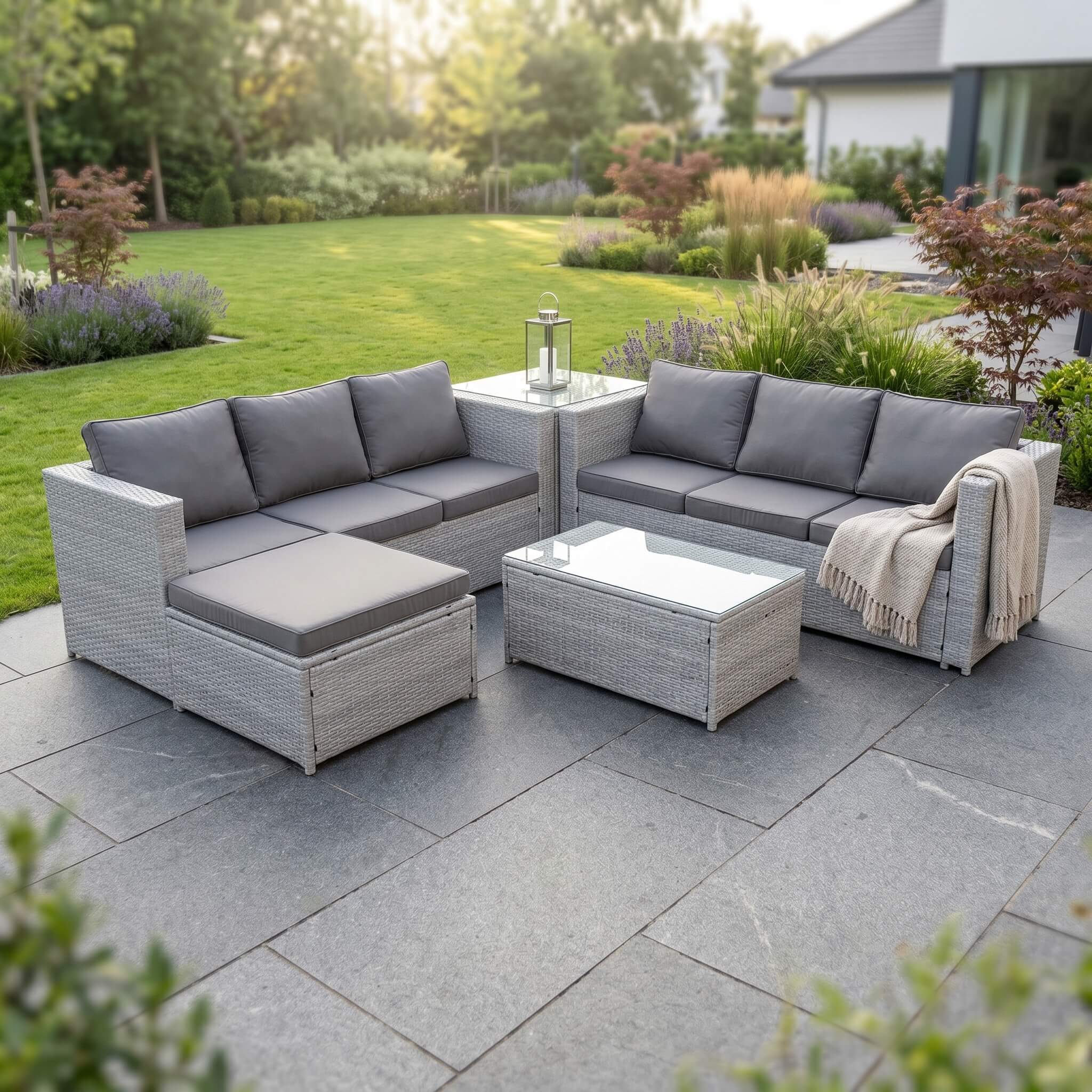 A Light Grey Outdoor Rattan Garden Furniture Set in an out garden