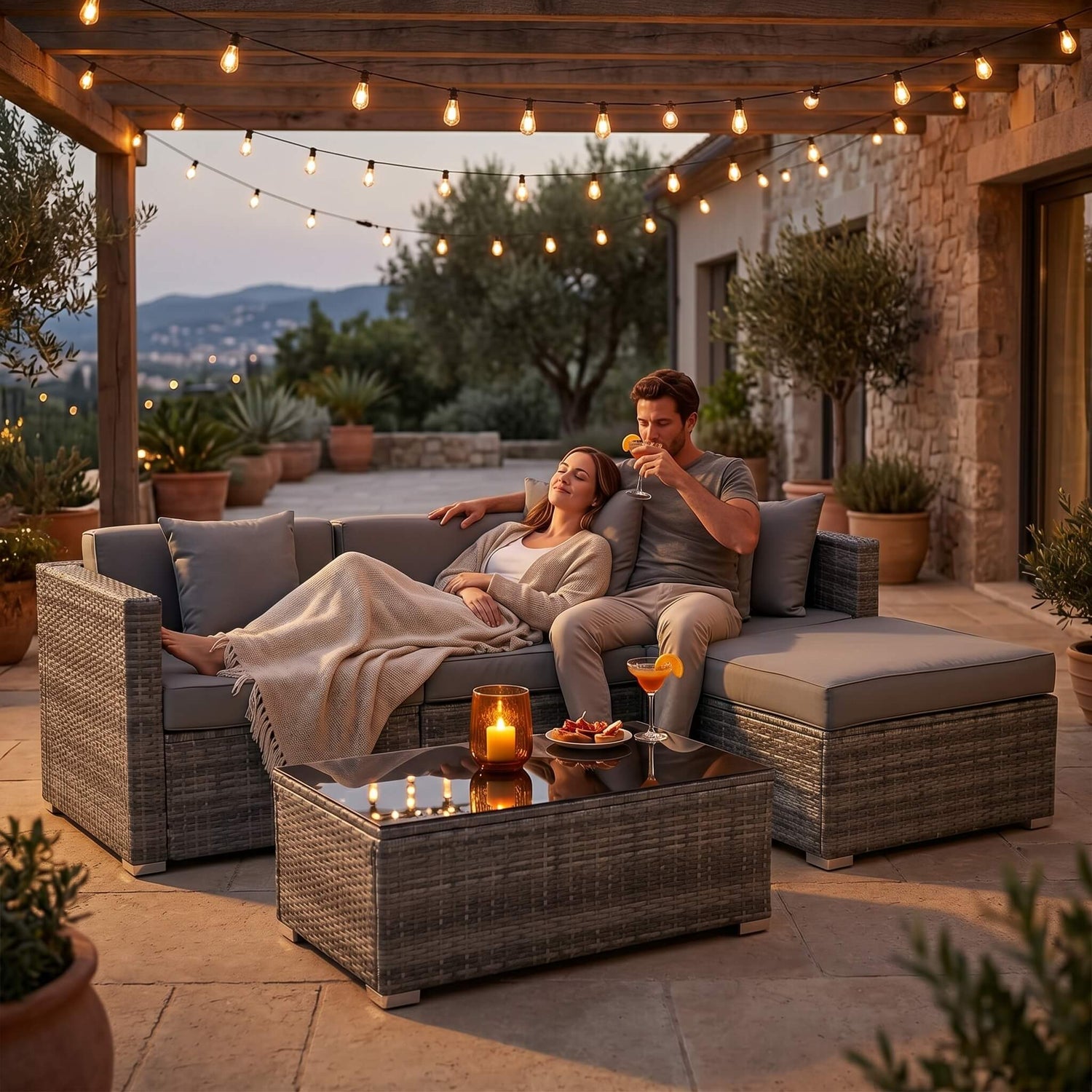 Couple enjoying a romantic evening on a patio with string lights and outdoor furniture.