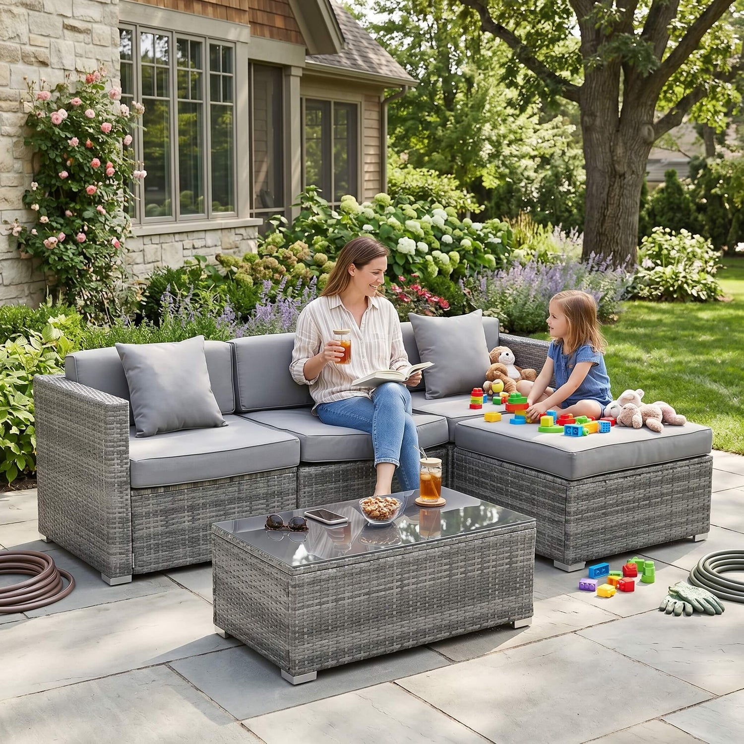 Woman reading a book to a child on a patio with outdoor furniture