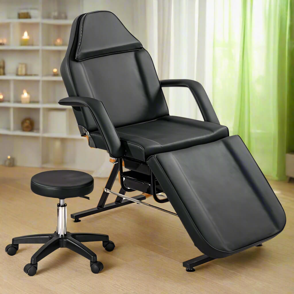 A black aromatherapy massage bed and black leather stool sold by WorkZen Interiors