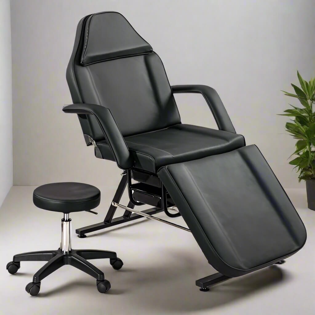 A black aromatherapy massage bed and black leather stool sold by WorkZen Interiors
