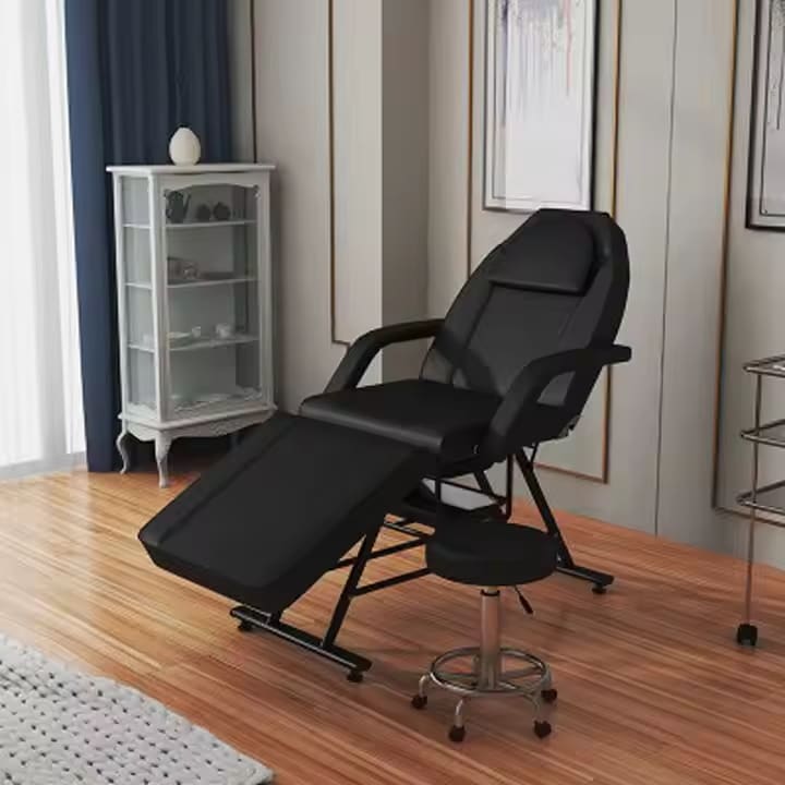 A black aromatherapy massage bed and a black stool sold by WorkZen Interiors