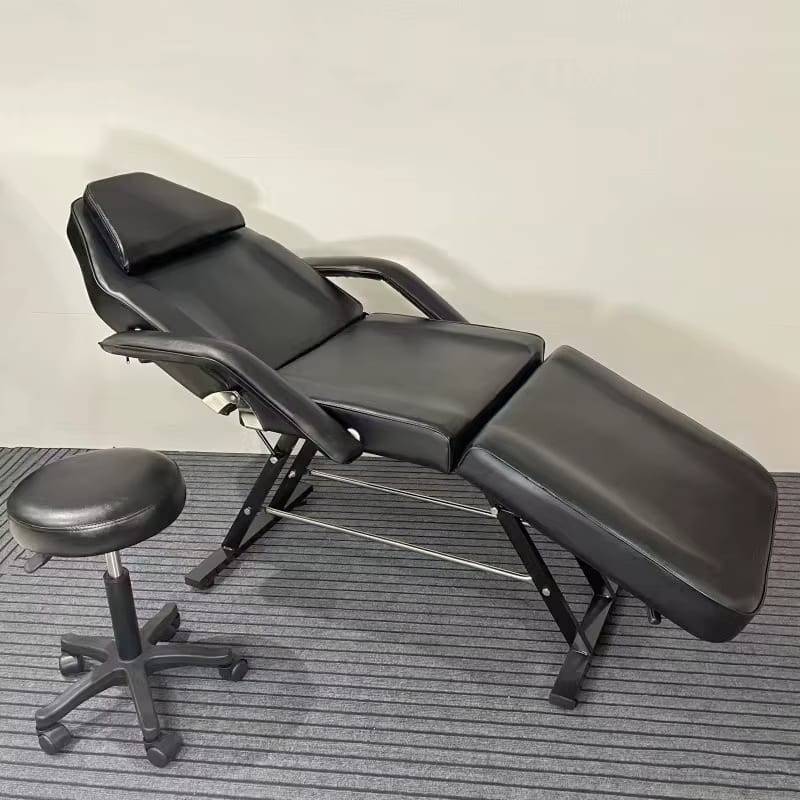 A black aromatherapy massage bed and a black stool sold by WorkZen Interiors