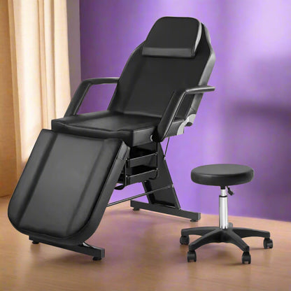 A black aromatherapy massage bed and black leather stool sold by WorkZen Interiors