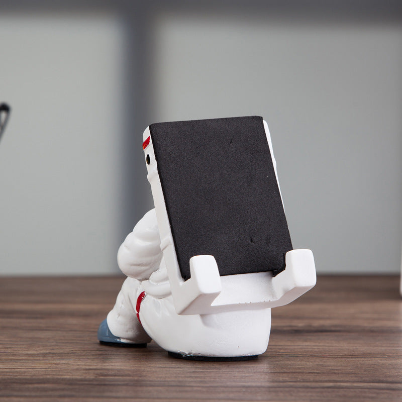 A white astronaut desk phone holder sold by WorkZen Interiors