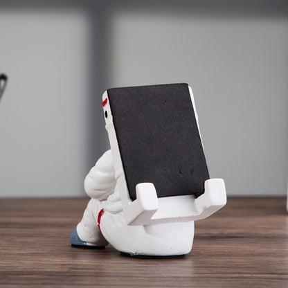 A white astronaut desk phone holder sold by WorkZen Interiors