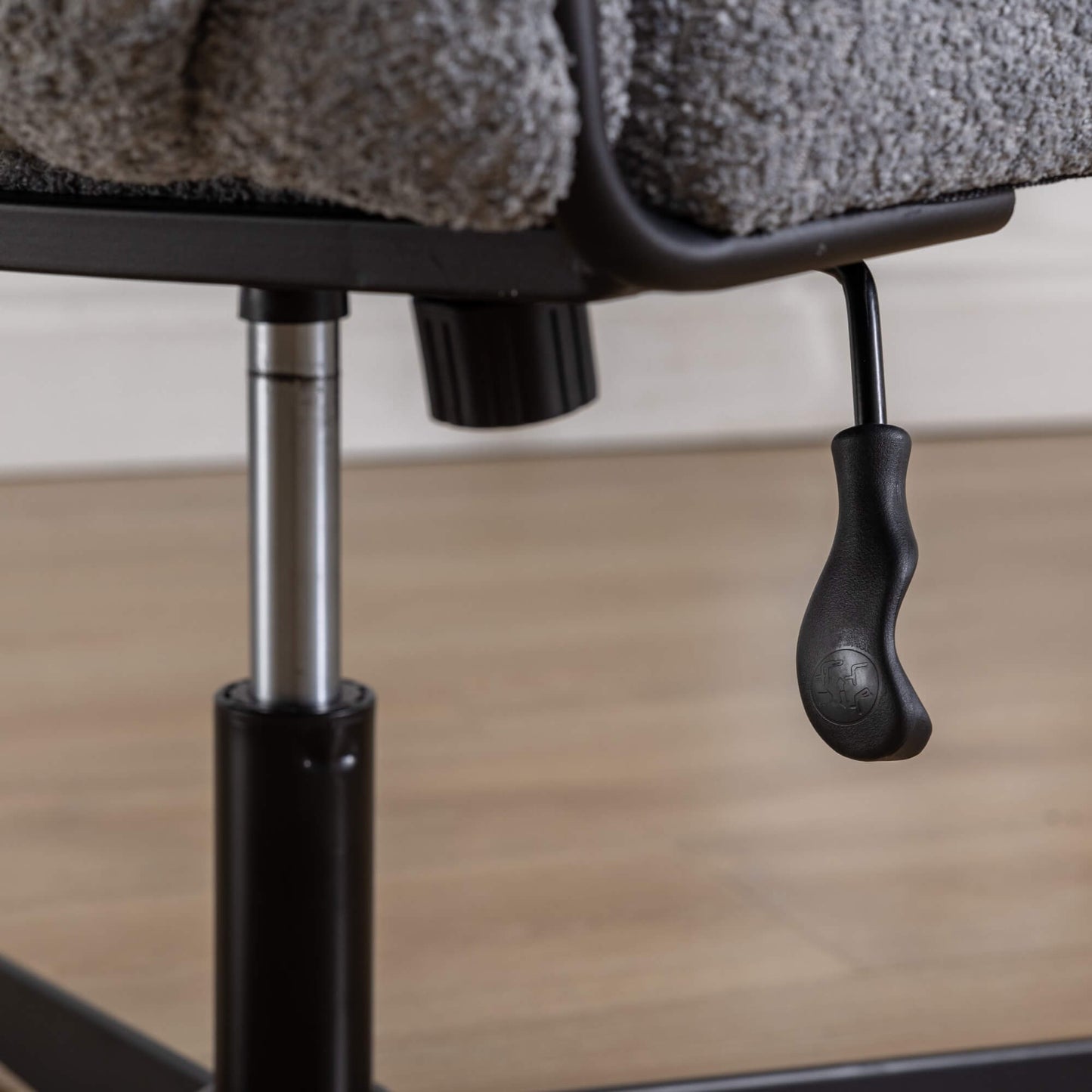 The recline adjustment lever of a Gray fabric office chair sold by WorkZen Interiors
