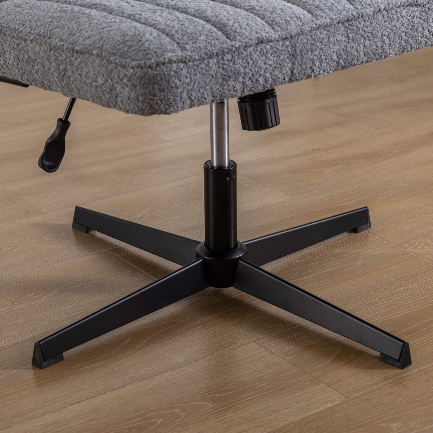 The height adjustment levers of a Gray fabric office chair sold by WorkZen Interiors