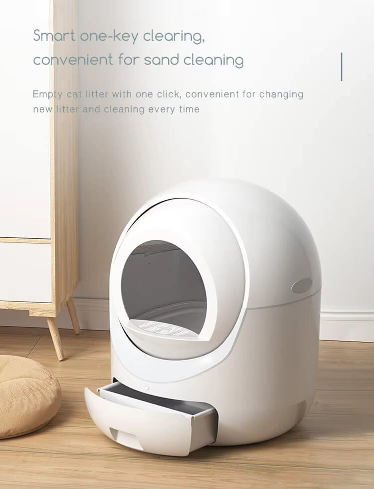 White automatic cat litter box on a wooden floor with text about its features.