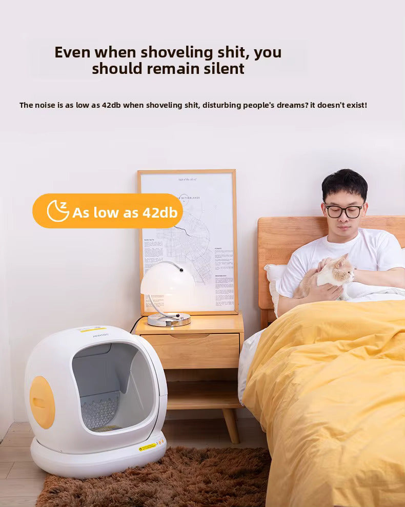 Person sitting on a bed with a cat, next to a white pet litter box with a yellow circle, in a bedroom setting.