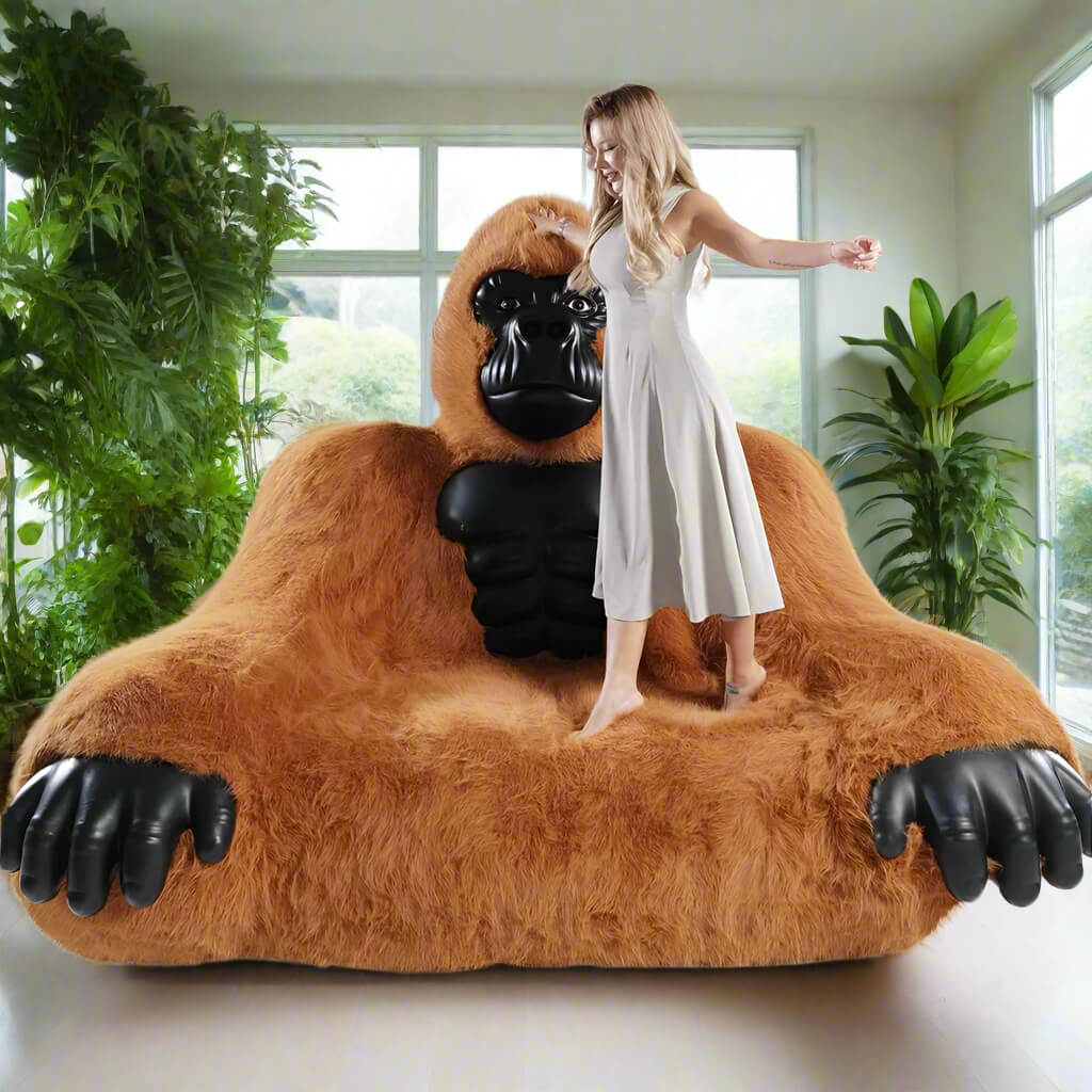A brown inflatable gorilla sofa sold by WorkZen Interiors with a beautiful woman standing on it.