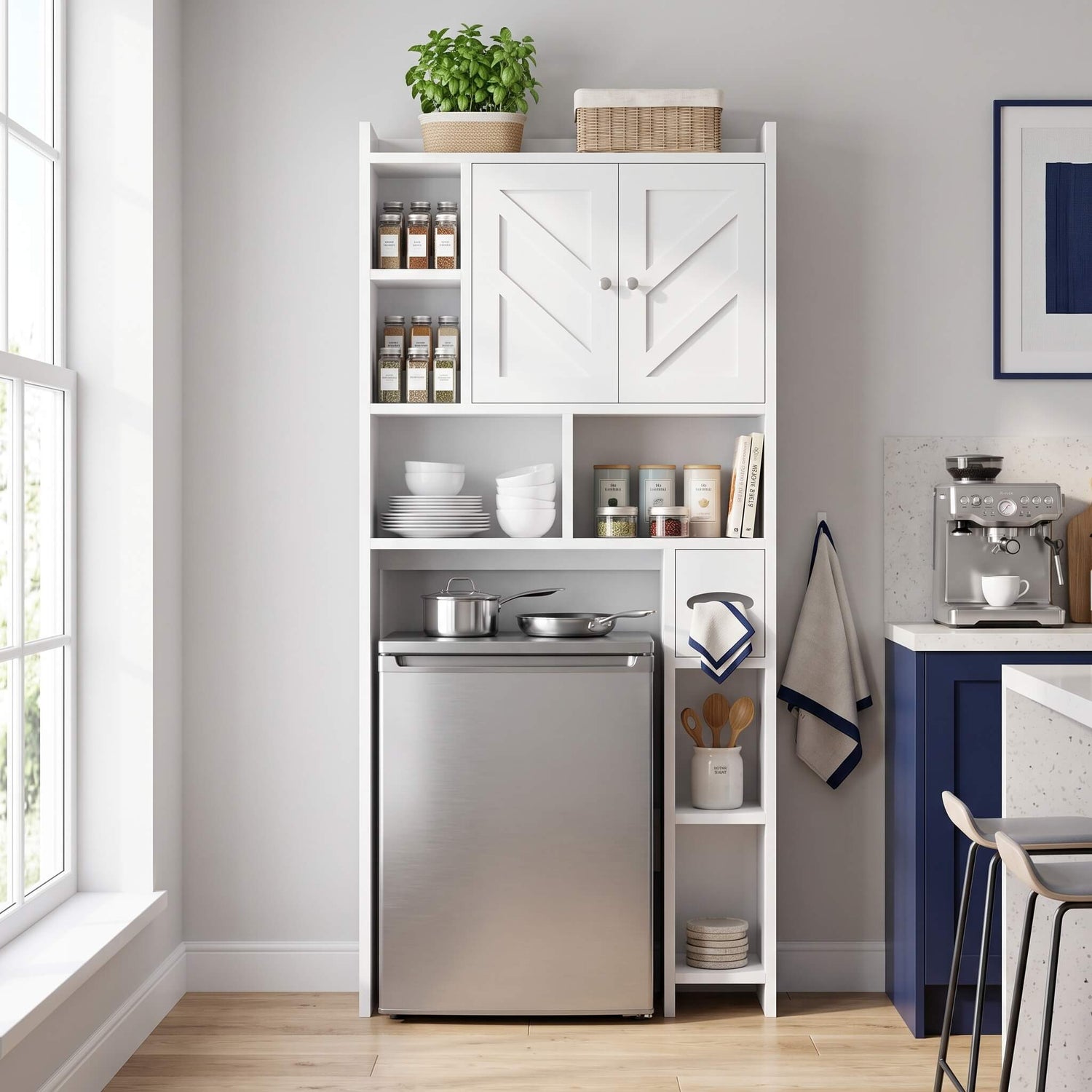 A tall over the toilet storage cabinet white​ with two upper doors, open shelves, and a lower stainless steel refrigerator, shown in a bright kitchen setting with a window, countertop, and blue cabinet.