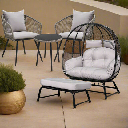 Outdoor furniture set with a round table, two chairs, and an ottoman on a patio.