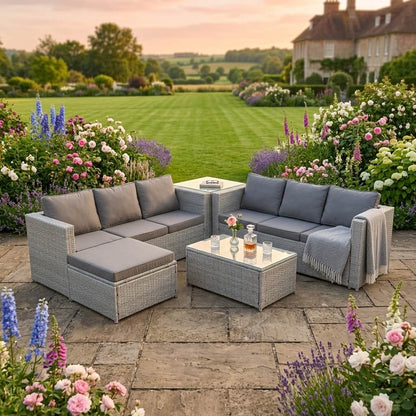 A Light Grey Outdoor Rattan Garden Furniture Set in an out garden