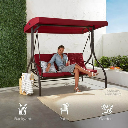 Woman sitting on a red outdoor swing with canopy in a garden setting