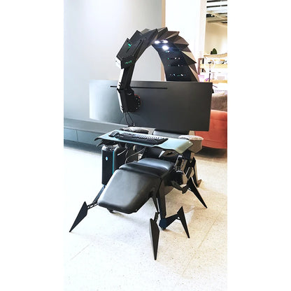 Scorpion gaming chair with built-in desk and computer setup in a room.