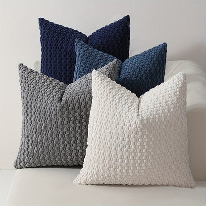 Textured throw pillows in blue, gray, and white on a sofa.
